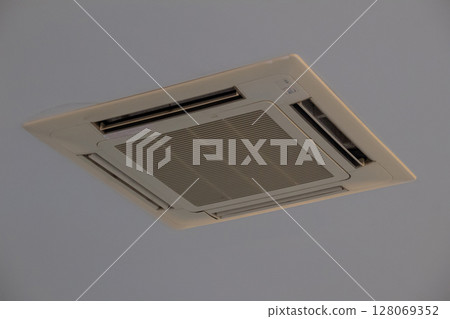 Modern square ceiling mounted air conditioning unit indoors for climate control 128069352