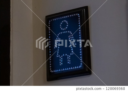 Framed womens restroom sign featuring geometric triangular pattern on blue background Framed womens restroom sign featuring geometric triangular pattern on blue background 128069368