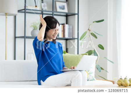 Middle-aged woman worried about her computer Middle-aged woman worried about her computer 128069715