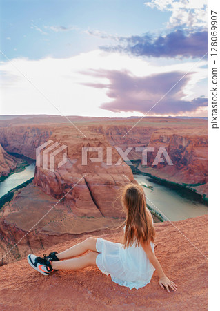 Happy girl on the edge of the cliff at Horseshoe Band Canyon in Page, Arizona. Adventure and tourism concept. Beautiful nature in USA 128069907