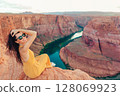 Beautiful woman on the edge of the cliff at Horseshoe Band Canyon in Page, Arizona. Beautiful nature in USA 128069923