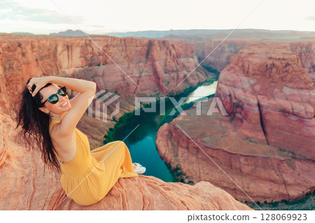 Beautiful woman on the edge of the cliff at Horseshoe Band Canyon in Page, Arizona. Beautiful nature in USA Beautiful woman on the edge of the cliff at Horseshoe Band Canyon in Page, Arizona. Beautiful nature in USA 128069923