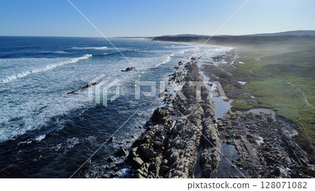 Striated Coastal Cliffs Meeting Turbulent Turquoise Seas 128071082