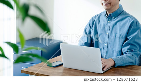 一名男子操作智慧型手機和電腦 128071628