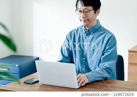 一名男子操作智慧型手機和電腦 128071629