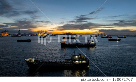 Aerial view oil tanker ship and gas tanker ship at sunset, Silhouette oil and gas tanker ship at oil and gas terminal, Global business import export logistic transportation oil and gas petroleum. Aerial view oil tanker ship and gas tanker ship at sunset, Silhouette oil and gas tanker ship at oil and gas terminal, Global business import export logistic transportation oil and gas petroleum. 128071707