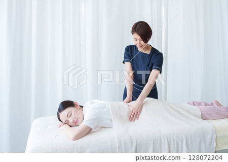 Aesthetician treating a customer 128072204