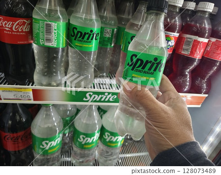 Indonesia,Kediri East Java june, 25 2025-Hand pickup a new bottle of SPRITE Plus Lemon Zero Sugar for sell on the supermarket Indonesia,Kediri East Java june, 25 2025-Hand pickup a new bottle of SPRITE Plus Lemon Zero Sugar for sell on the supermarket 128073489