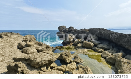 A stunning view of a rocky coastline with the ocean stretching to the horizon under a clear blue sky. Kedung tumpang beach in Tulungagung indonesia A stunning view of a rocky coastline with the ocean stretching to the horizon under a clear blue sky. Kedung tumpang beach in Tulungagung indonesia 128073733