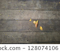 leaves fall on wooden floor, Wooden textured surface with natural leaves background 128074106