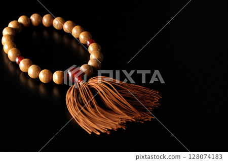 Single shot of prayer beads against a black background 128074183