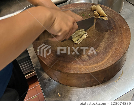 Filming the chef skillfully slicing ginger in the restaurant's kitchen 128074889