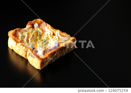 Pizza toast photographed alone on a black background Pizza toast photographed alone on a black background 128075259