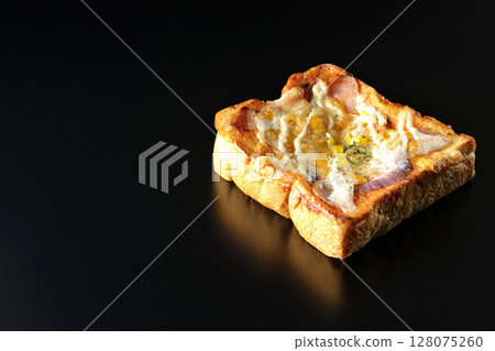 Pizza toast photographed alone on a black background Pizza toast photographed alone on a black background 128075260