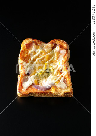 Pizza toast photographed alone on a black background Pizza toast photographed alone on a black background 128075283