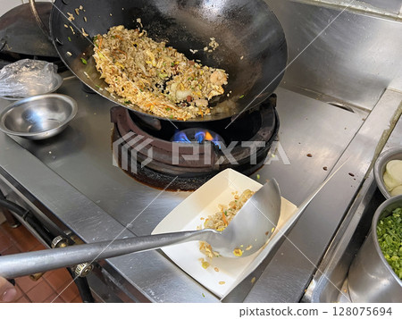 Filming the chef putting the prepared fried rice into a takeaway box Filming the chef putting the prepared fried rice into a takeaway box 128075694