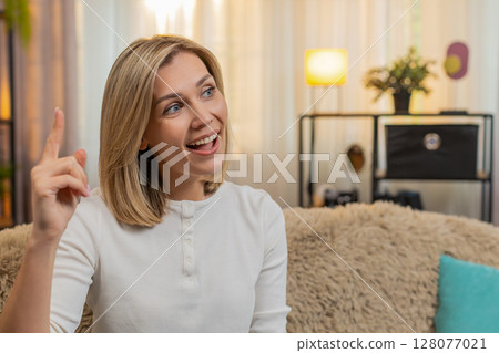 Adult woman opening eyes with surprise, reacting with excitement after discovering idea or solution 128077021