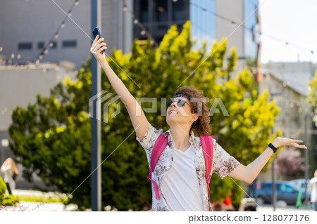 Tourist with backpack trying to catch a communication signal and Internet connection on mobile phone Tourist with backpack trying to catch a communication signal and Internet connection on mobile phone 128077176