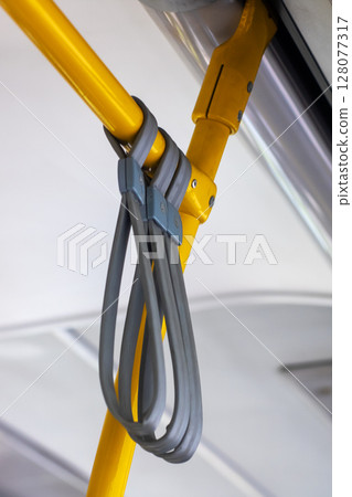 A yellow pole with a gray strap securely attached to it, 128077317