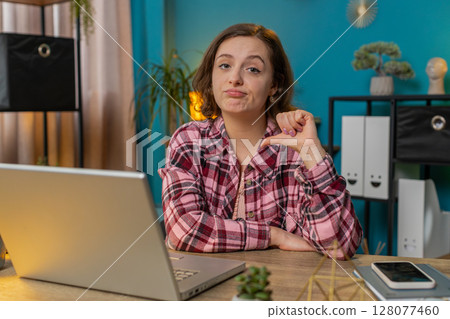 Businesswoman working on laptop computer at home office showing thumbs down sign dislike disapproval 128077460