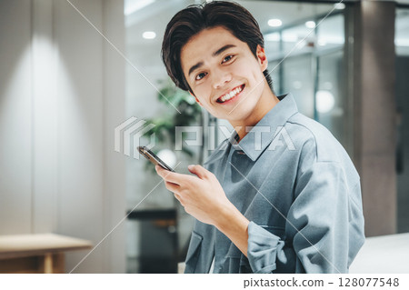 Businessman using a smartphone in the office Photo cooperation: WEEK Shibadaimon (Sun Frontier Fudousan) Businessman using a smartphone in the office Photo cooperation: WEEK Shibadaimon (Sun Frontier Fudousan) 128077548