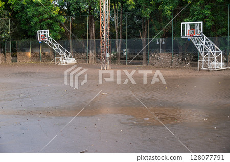 Basketball court having damaged and mud flooded after Kok river rising and flooding Chiang Rai province, Thailand. 128077791