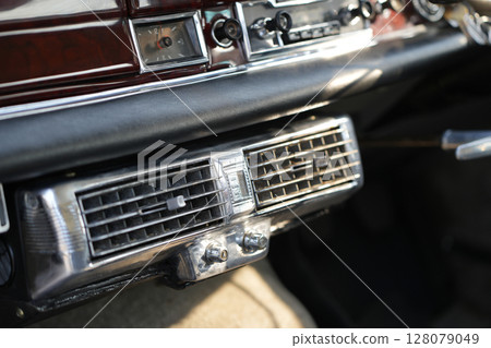 Classic car air vents are captured in close up, focusing on their structure and function, proving the system still works effectively and looks visually clean. 128079049