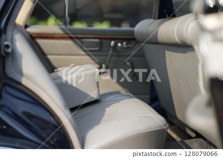 Leather rear seats of a vintage classic car mid-20th century automotive craftsmanship, with textured surfaces, comfort and retro aesthetics. 128079066