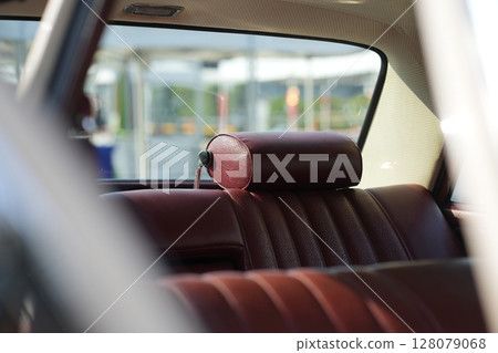 Leather rear seats of a vintage classic car mid-20th century automotive craftsmanship, with textured surfaces, comfort and retro aesthetics. 128079068