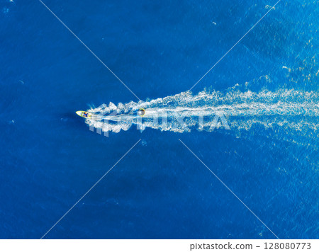 Vacation and leisure. Seascape with motorboat. Aerial view on fast boat on blue sea at sunny day.  Vacation and leisure. Seascape with motorboat. Aerial view on fast boat on blue sea at sunny day.  128080773