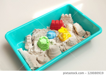 Kinesthetic sand and shapes in sandbox for children. Toys and motor skills development. Royal castle, tower and construction site. Kinesthetic sand and shapes in sandbox for children. Toys and motor skills development. Royal castle, tower and construction site. 128080919