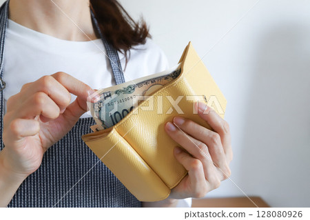 Woman paying money out of her wallet 128080926