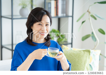 Middle-aged woman drinking herbal tea Middle-aged woman drinking herbal tea 128083661