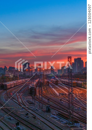 Urban railroad tracks and trains under the blue sky and red sunset 128084097