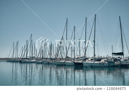 Row of sailboat docked in calm marina Row of sailboat docked in calm marina 128084875