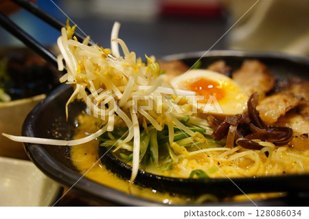 Close-up of Japanese Ramen Noodles with Chashu Pork, Soft-Boiled Egg, and Bean Sprouts in a Black Bowl Close-up of Japanese Ramen Noodles with Chashu Pork, Soft-Boiled Egg, and Bean Sprouts in a Black Bowl 128086034