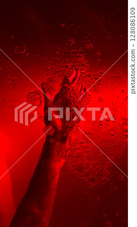 A Striking Visual of a Hand Surrounded by Bubbles Underwater in a Enigmatic Red Hue, Creating an Intriguing Atmosphere of Mystery and Depth A Striking Visual of a Hand Surrounded by Bubbles Underwater in a Enigmatic Red Hue, Creating an Intriguing Atmosphere of Mystery and Depth 128086109