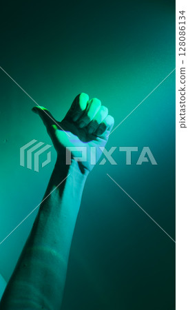 A Captivating Green-Hued Image of a Hand Displaying a Thumbs Up Gesture Submerged in Ethereal Light 128086134