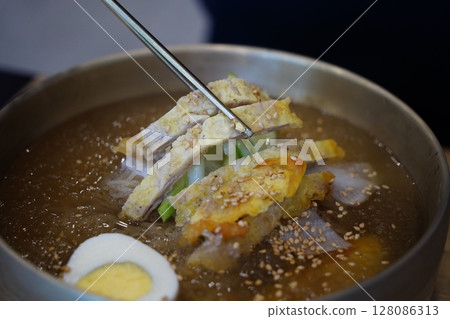 Close-up of Korean Naengmyeon Cold Noodles Topped with Sliced Beef Pancake (Yukjeon) Close-up of Korean Naengmyeon Cold Noodles Topped with Sliced Beef Pancake (Yukjeon) 128086313