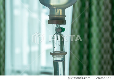 Close up medical intravenous IV drip in hospital background Close up medical intravenous IV drip in hospital background 128086862