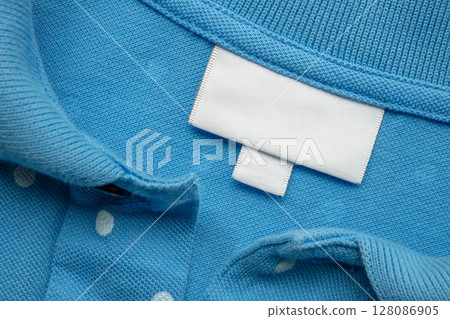 White blank laundry care clothes label on shirt fabric background 128086905