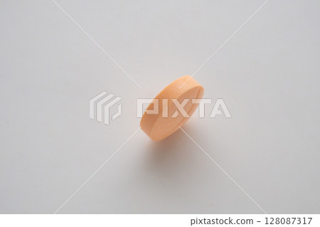 Orange medicine pill tablet on white background Orange medicine pill tablet on white background 128087317
