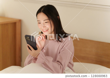一位女士半夜看著她的智慧型手機 128088963