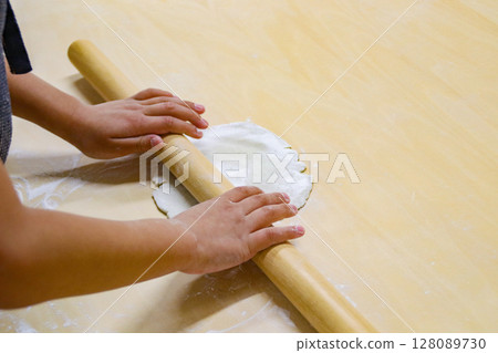 孩子用擀麵棍擀蕎麥麵團（7歲男孩） 128089730