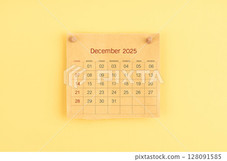 December 2025 brown calendar with wooden thumbtack on yellow color background. 128091585