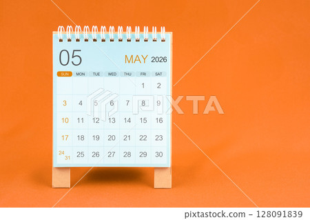 May 2026 desk calendar stand on orange color textile background. 128091839