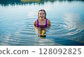 Happy woman bathing in a lake creating water rings 128092825