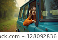 Young woman looking out of car window enjoying nature 128092836