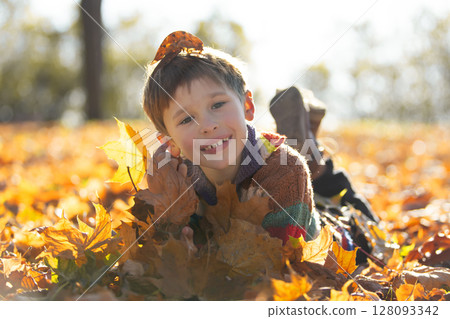 Happy little boy in the autumn park. 128093342