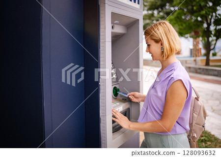 Enjoying summer in Greece while using an ATM machine 128093632